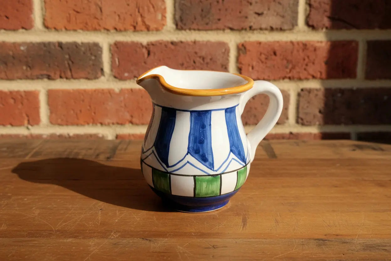 Ceramic pitcher with blue and white striped design 