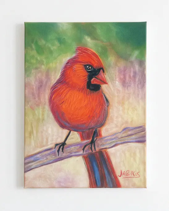 Framed artwork of a red cardinal bird on a branch against a textured wall.