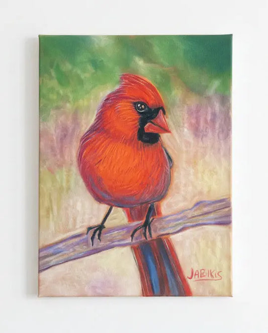 Framed artwork of a red cardinal bird on a branch against a textured wall.