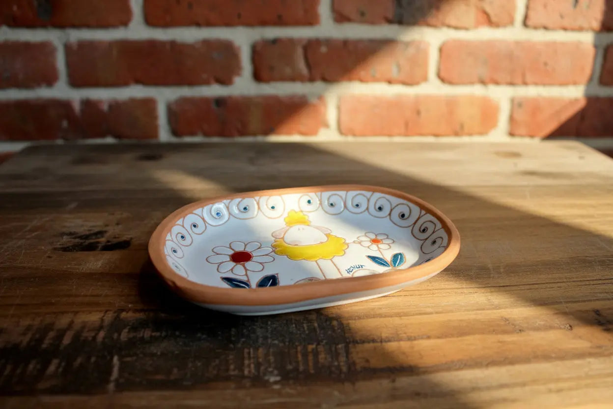 Decorative ceramic tray with a cartoon character and floral design 