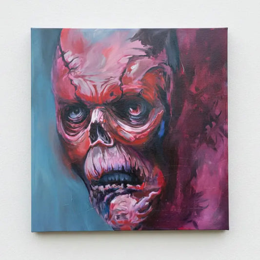 Painting of a stylized, colorful face with a red and pink color scheme on a blue surface.